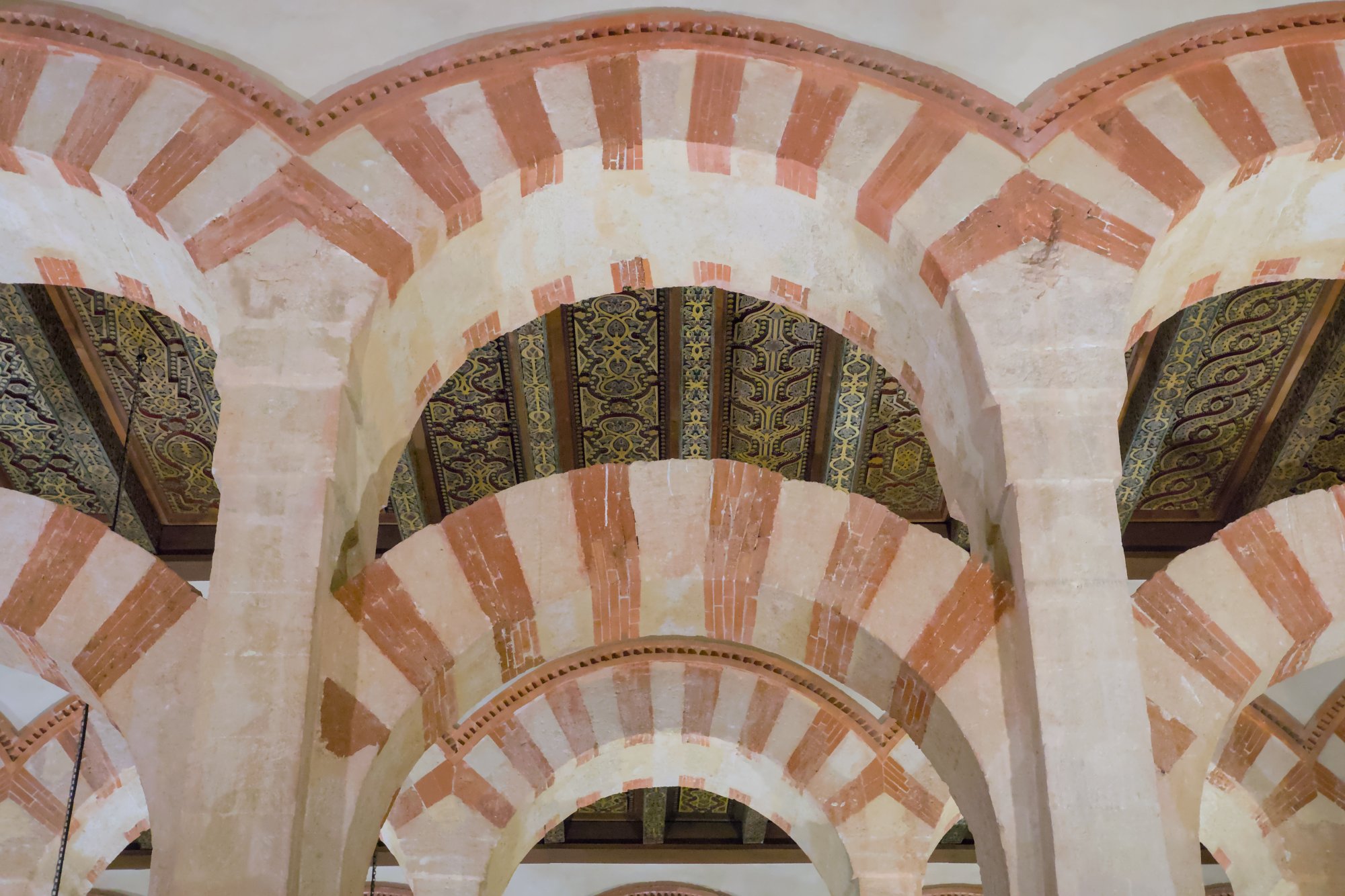 Red and white striped double arches and carved ceilings inside the Mosque-Cathedral of Cordoba