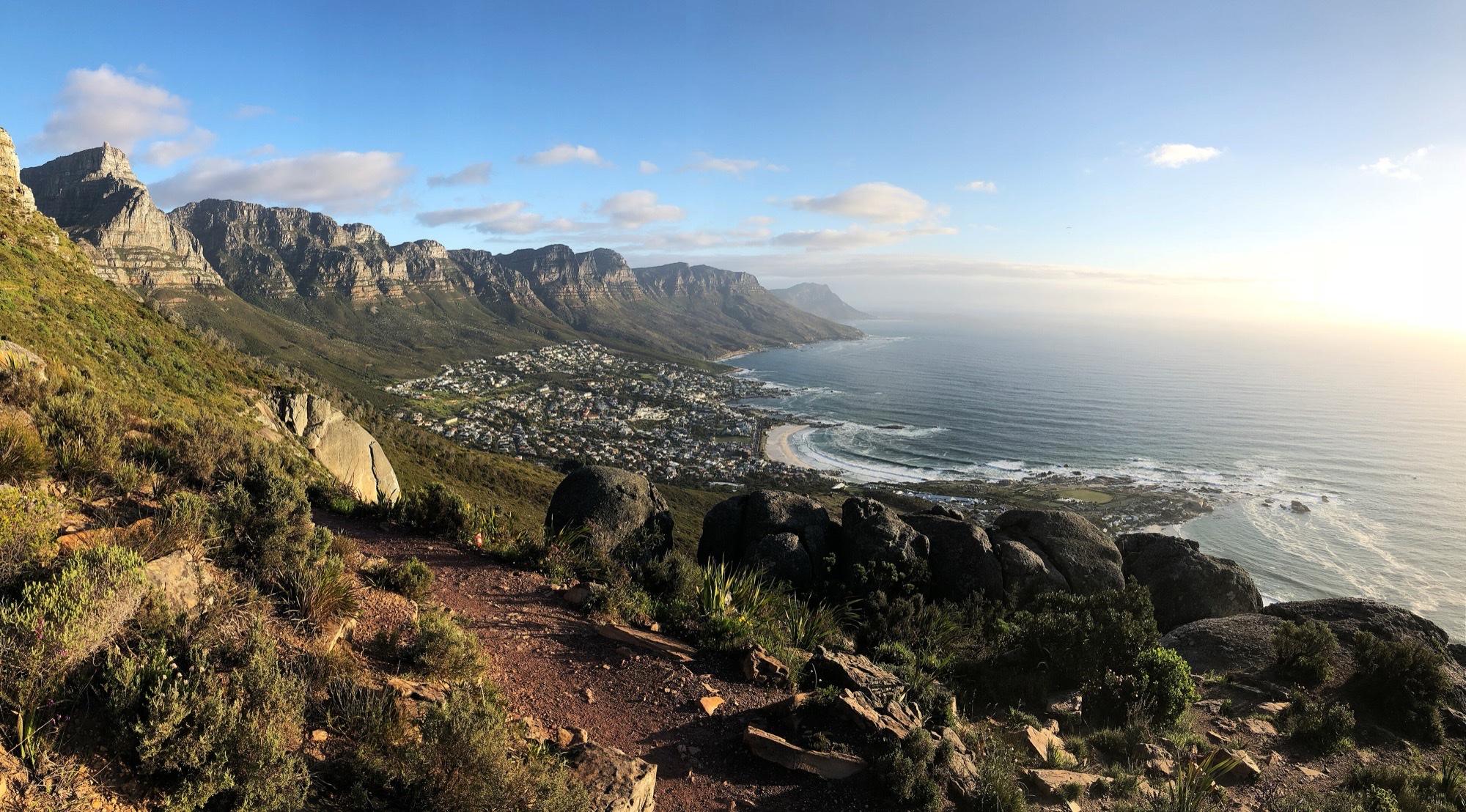 View from the Lion's Head path down to Camps Bay beach and the Twelve Apostles ridge on a clear summer afternoon