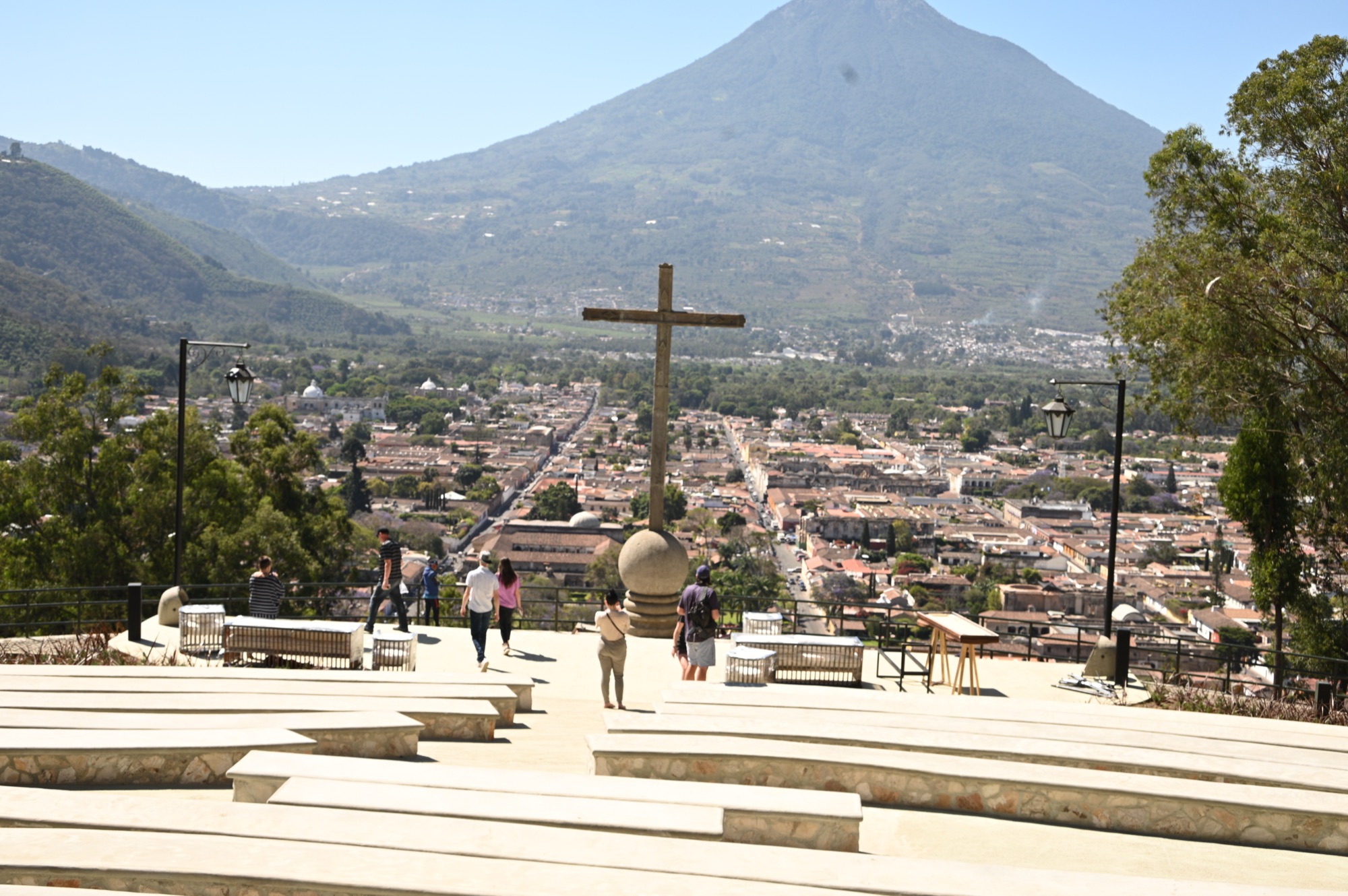 The stone cross on the Cerro de la Cruz terrace above Antigua with the town's tiled roofs and Volcan de Agua beyond