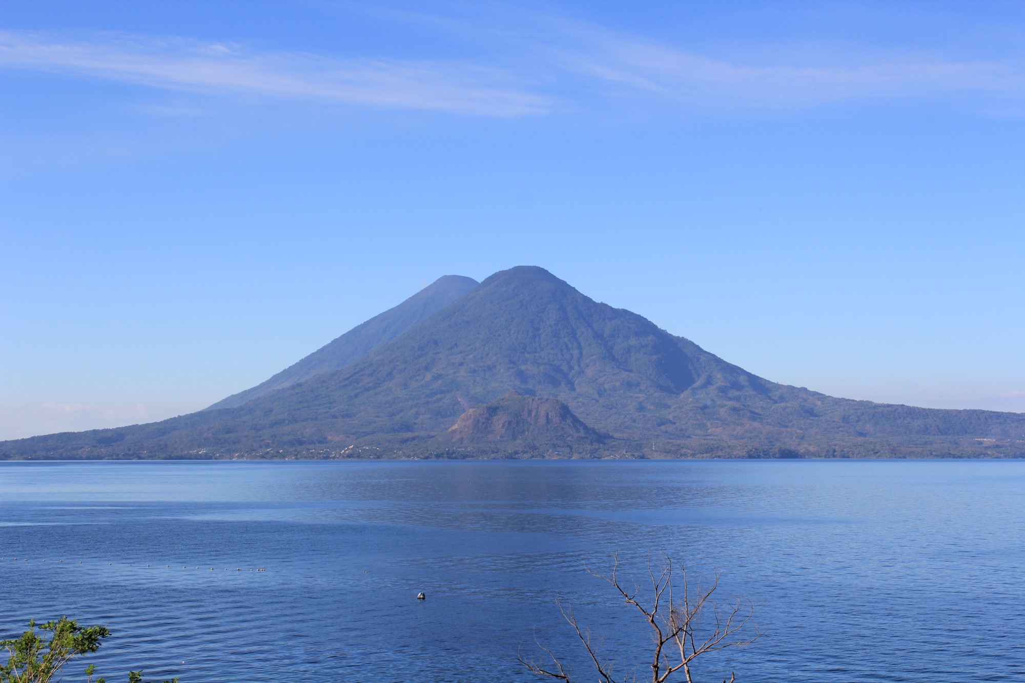 Lake Atitlan under a clear sky with the twin cones of Volcan Toliman and Volcan Atitlan across the water from Panajachel