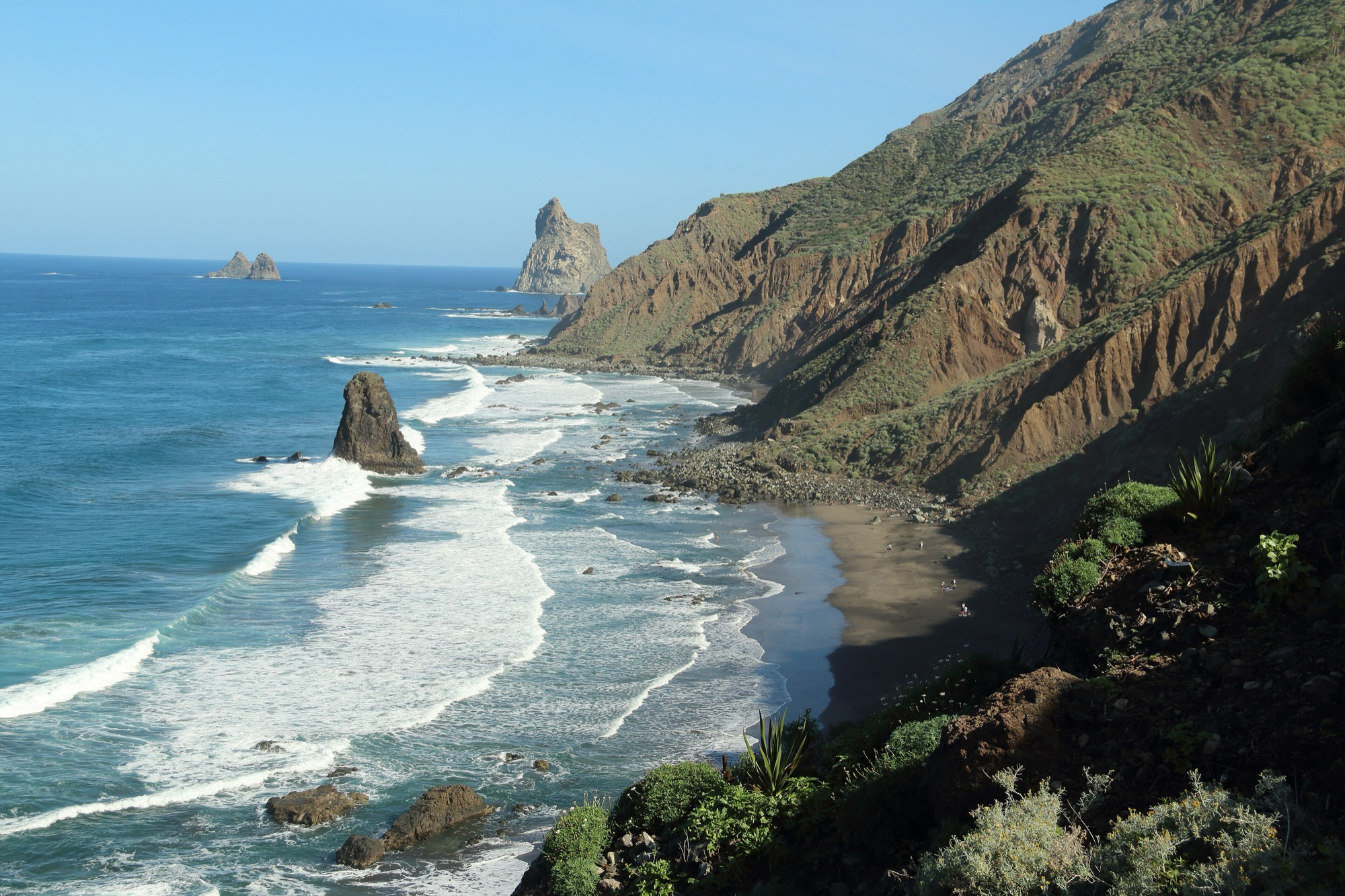 Black-sand Benijo beach with white surf, rock stacks offshore and the steep green ridges of Anaga