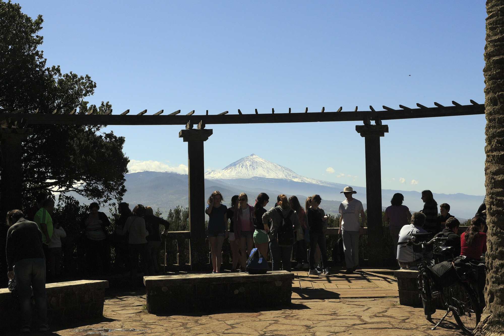 Visitors at the Cruz del Carmen viewpoint in Anaga looking across the island to a snow-capped Teide