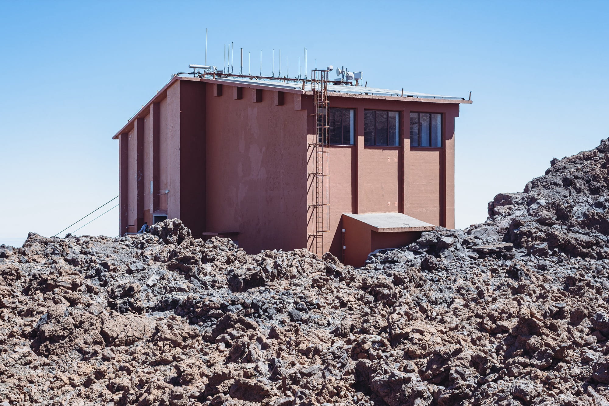 Upper station of the Teide cable car at La Rambleta among dark lava blocks under a clear sky
